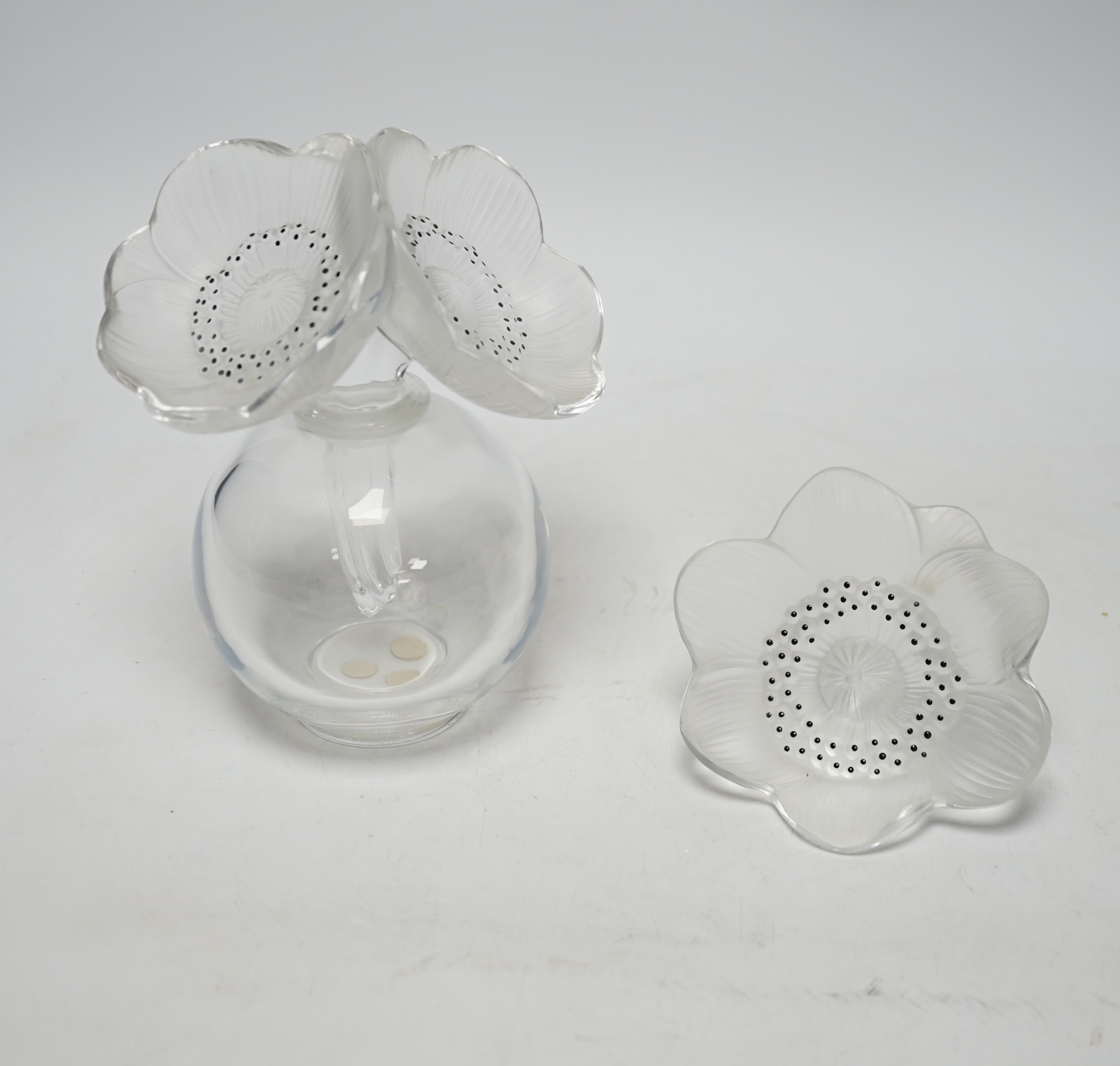 A Lalique anemone glass scent bottle and stopper, signed to the base, together with an associated anemone stopper, 16cm high